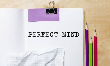 Ofisteki masanın üstünde kalemlerle bir kağıda yazılmış mükemmel zihin metni.