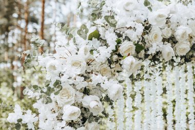 Doğada bir düğün töreni için beyaz çiçeklerle süslenmiş kemer.