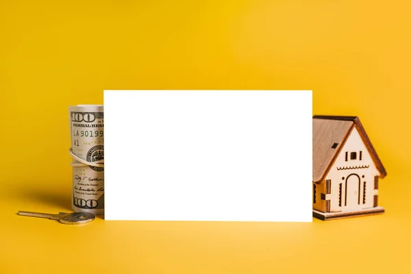 House miniature model and money with blank background on a yellow background. Investment, real estate, home, housing