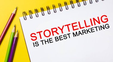 Metin Öyküleme, sarı arka planda kalemleri olan beyaz bir not defterindeki en iyi pazarlamadır. İş konsepti