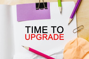 Tahta arka planda kalemler olan beyaz bir not defterini güncelleme zamanı. İş konsepti