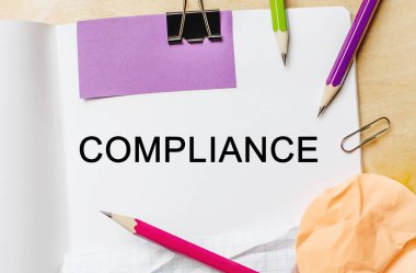 Ahşap zemin üzerinde kalemler olan beyaz bir not defterine metin kompleksi. İş konsepti