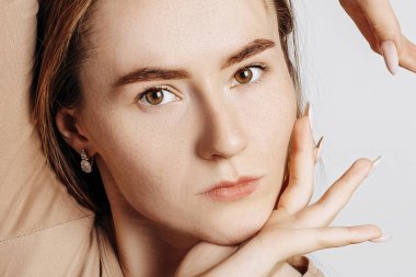 Güzel, genç, esmer bir kadın beyaz izole bir arka planda kameraya bakıyor. Güzel surat..