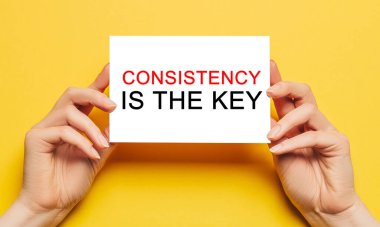 Sarı arkaplandaki anahtar, yazı tutarlılığında kart tutan kadın elleridir. İş ve finans kavramı