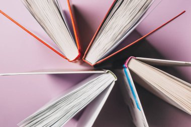 Pembe arka planda kitapları aç. Eğitime ve okuma konseptine ayak uydur. Öğrenim, gelişme ve neşe edebiyatı