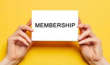 Sarı arka planda yazılı kart olan kadın eli kağıdı tutuyor. İş ve finans kavramı