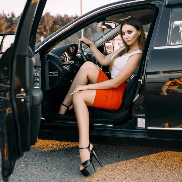 Piękna Młoda Dziewczyna Prowadzi Samochód Wieczorem Słońcu Pustym Parkingu — Zdjęcie stockowe