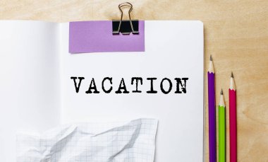 Ofisteki masanın üstünde kalemlerle bir kağıda yazılmış tatil metni.
