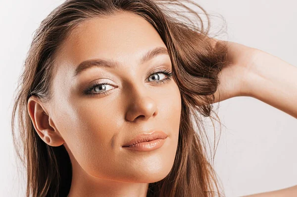 Gülümseyen ve poz veren güzel bir genç kız beyaz izole bir arka planda kameraya bakıyor. Pozitif esmer kadın. Nazik bak. Güzel surat..