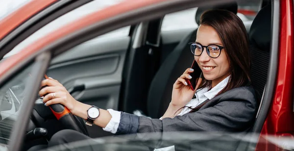 운전대를 소녀는 전화기를 메시지를 읽습니다 주차장에 여자가 자동차 — 스톡 사진