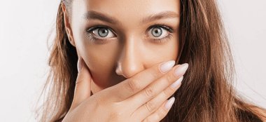 Gülümseyen ve poz veren güzel bir genç kız beyaz izole bir arka planda kameraya bakıyor. Pozitif esmer kadın. Nazik bak. Güzel surat..