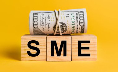 Sarı arka planda paralı KOBİ. İş, finans, kredi, gelir, tasarruf, yatırım, takas, vergi kavramı