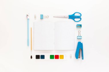 Okul gereçleri ve kırtasiye malzemeleriyle dolu modern beyaz ofis masaüstünün en üst görüntüsü mesaj için boş alan etrafında. Okula dönüş konsepti dairesi modelle yatıyordu.