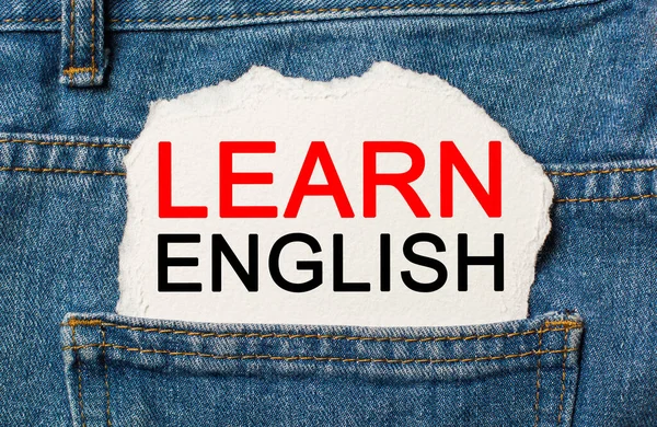 Learn ENGLISH on torn paper background on jeans study and education concept