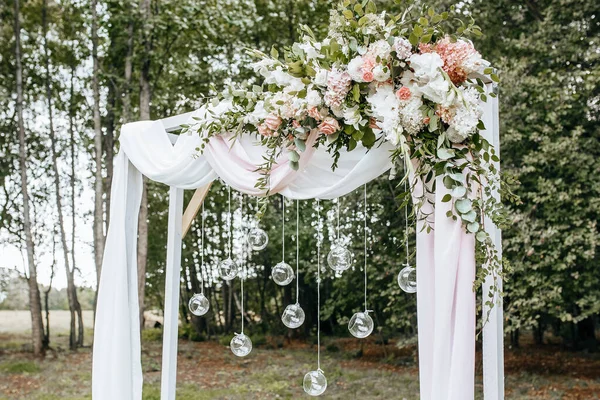 自然の中で結婚式のための花や布でアーチを飾る — ストック写真