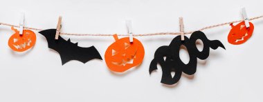 Cadılar bayramı konseptin kutlu olsun. Yarasalar, balkabakları ve hayaletler ipte, beyaz izole arkaplanda mandalla.