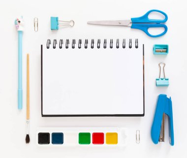 Okul gereçleri ve kırtasiye malzemeleriyle dolu modern beyaz ofis masaüstünün en üst görüntüsü mesaj için boş alan etrafında. Okula dönüş konsepti dairesi modelle yatıyordu.