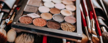 Makyaj sanatçısı çalışırken makyaj fırçaları ve kozmetik ürünleri yalan söyler.