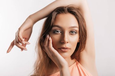 Gülümseyen ve poz veren güzel bir genç kız beyaz izole bir arka planda kameraya bakıyor. Pozitif esmer kadın. Nazik bak. Güzel surat..