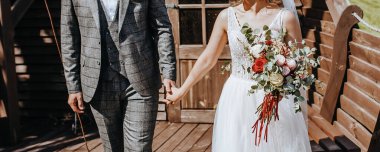 Gelin ve damat düğün gününde bir buket gül çiçeğiyle kucaklaşır ve sevgiyi gösterir