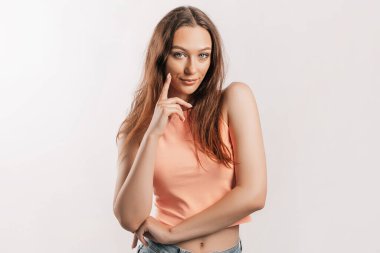 Gülümseyen ve poz veren güzel bir genç kız beyaz izole bir arka planda kameraya bakıyor. Pozitif esmer kadın. Nazik bak. Güzel surat..