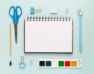 Okul gereçleri ve kırtasiye malzemeleriyle dolu modern beyaz ofis masaüstünün en üst görüntüsü mesaj için boş alan etrafında. Okula dönüş konsepti dairesi modelle yatıyordu.