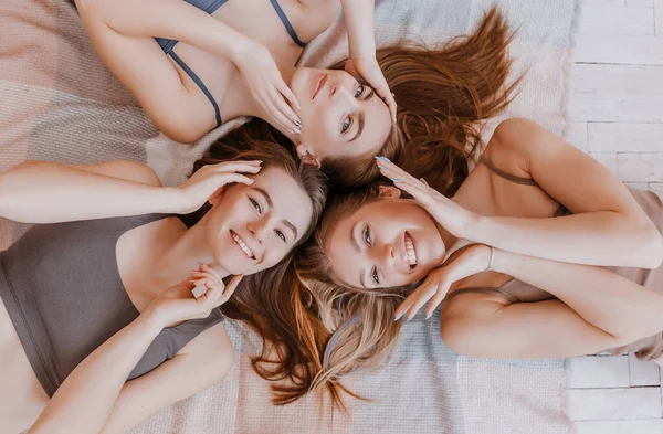 Γυναίκες Ξεκουράζονται Και Διασκεδάζουν Φίλες Γελάνε Στο Σπίτι Ξαπλωμένες Στο — Φωτογραφία Αρχείου
