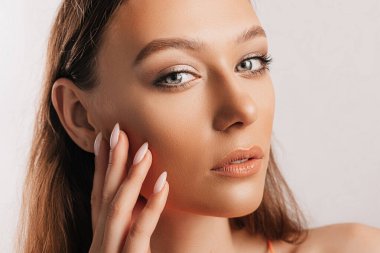 Gülümseyen ve poz veren güzel bir genç kız beyaz izole bir arka planda kameraya bakıyor. Pozitif esmer kadın. Nazik bak. Güzel surat..