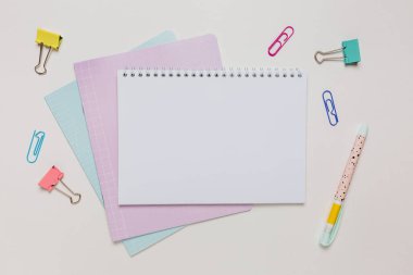 Not defteri, egzersiz kitabı ve kalem masaya. Fotokopi odasında beyaz arka planda. Okula geri dön.