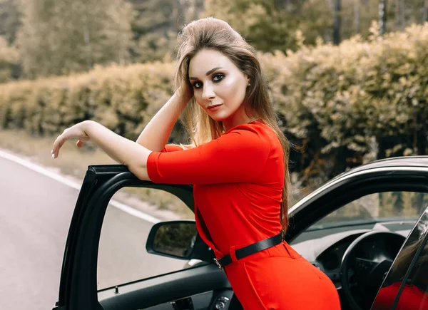 Una Hermosa Joven Mono Rojo Encuentra Junto Coche Negro Camino — Foto de Stock