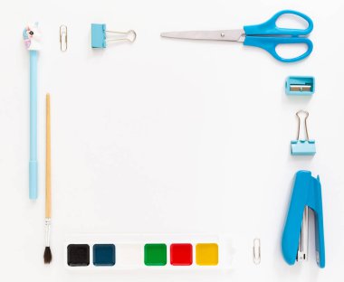 Okul gereçleri ve kırtasiye malzemeleriyle dolu modern beyaz ofis masaüstünün en üst görüntüsü mesaj için boş alan etrafında. Okula dönüş konsepti dairesi modelle yatıyordu.