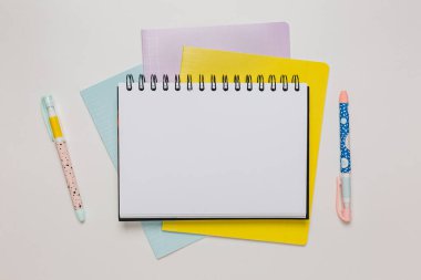 Not defteri, egzersiz kitabı ve kalem masaya. Fotokopi odasında beyaz arka planda. Okula geri dön.