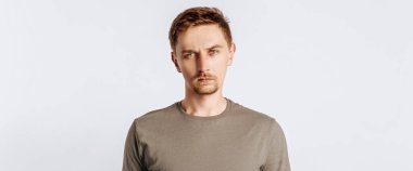 Sakallı yakışıklı esmer adam beyaz soyutlanmış arka plandan memnun değil.