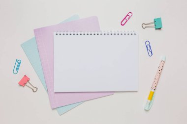 Not defteri, egzersiz kitabı ve kalem masaya. Fotokopi odasında beyaz arka planda. Okula geri dön.