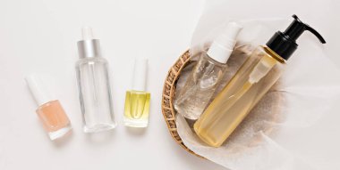 Organik kozmetik ambalaj tasarımı. Düz yerde, cam pompa şişesi, fırça kavanozu, beyaz arka planda kağıt sepette nemlendirici serum. Doğal Kozmetik SPA