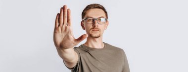 Gözlüklü, sakallı, genç, yakışıklı, esmer bir adam elini uzattı ve beyaz izole arka planda dur dedi.