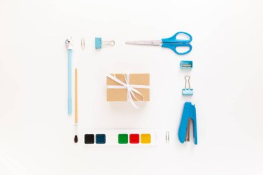 Okul gereçleri ve kırtasiye malzemeleriyle dolu modern beyaz ofis masaüstünün en üst görüntüsü mesaj için boş alan etrafında. Okula dönüş konsepti dairesi modelle yatıyordu.