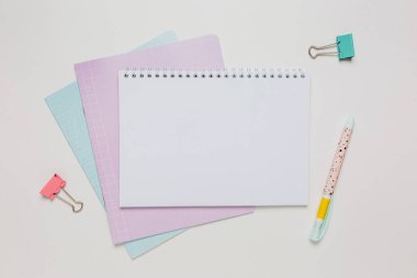 Not defteri, egzersiz kitabı ve kalem masaya. Fotokopi odasında beyaz arka planda. Okula geri dön.