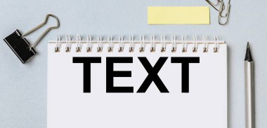 TEXT. Kırtasiyeli işyerinin düz düzeni. Beyaz ve mavi arkaplana izole edilmiş metin, kalem, defter, klasör klipleri ve raptiyeler için yeri olan boş çıkartmalar. Ofis malzemeleri hazır..