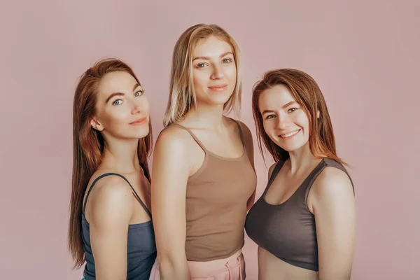 Drie Meisjes Comfortabele Huiskleding Samen Een Roze Achtergrond Vrouwen Lachen — Stockfoto