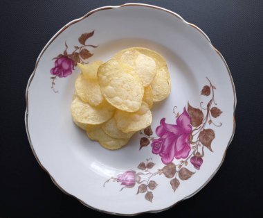 Eski bir tabakta patates cipsi..