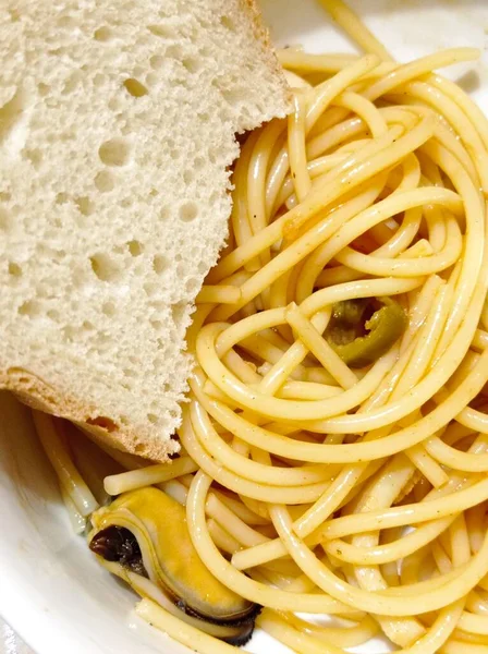 Midyeli spagetti, zeytin ve bir dilim ekmek..