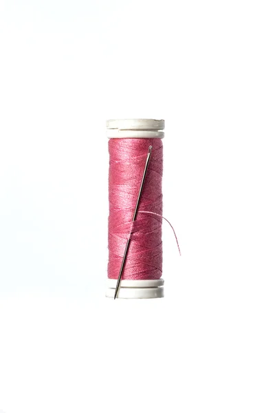 Aiguille intégrée dans une bobine de couture rose — Photo