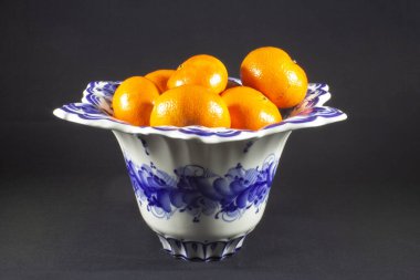 Siyah arka planda meyveli porselen kase.