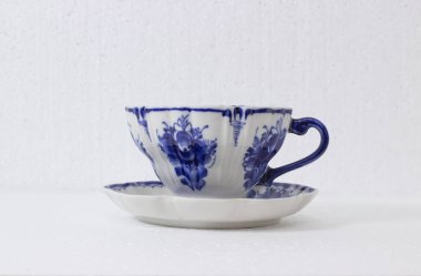 Mavi çiçekli porselen bardaklar masanın üzerinde duruyor.