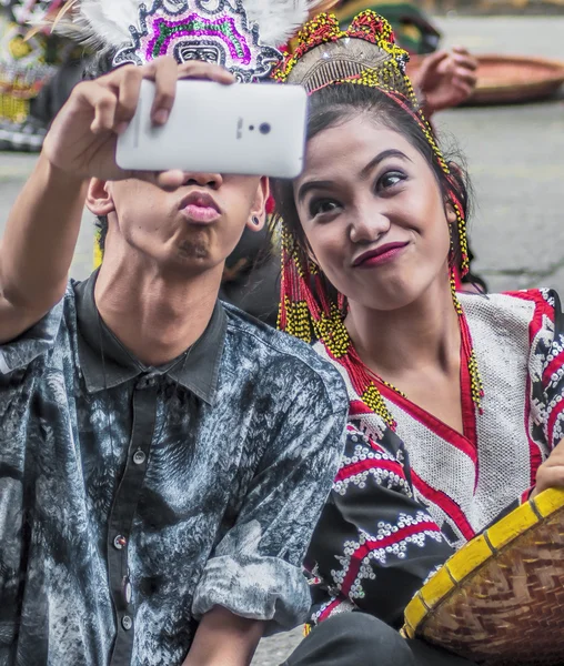 Виконавець бере на selfie зі своєю подругою, тільки, перш ніж Dinagyang фестиваль парад розпочався в Ілоіло, Філіппіни — стокове фото