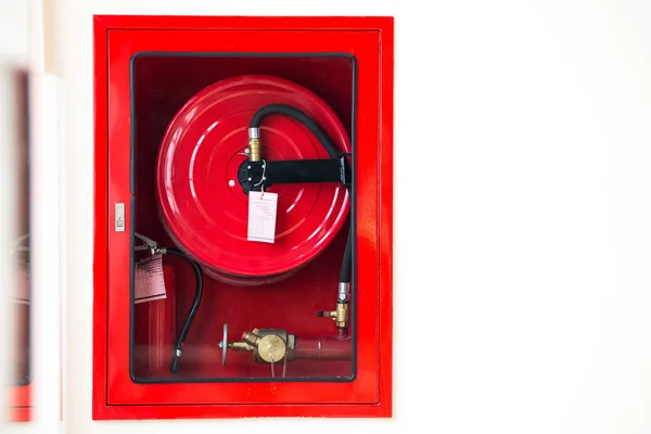 Attrezzature antincendio nella scatola rossa sul cemento a parete — Foto Stock