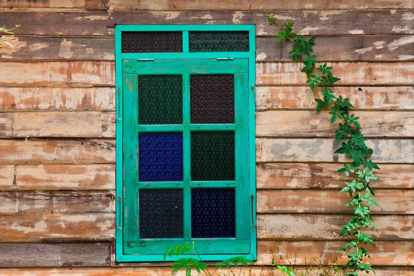 Groene framevenster van het oude rustieke huis op de achtergrond van houten muren — Stockfoto