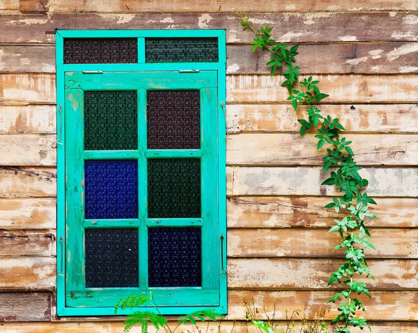 Groene framevenster van het oude rustieke huis op de achtergrond van houten muren — Stockfoto