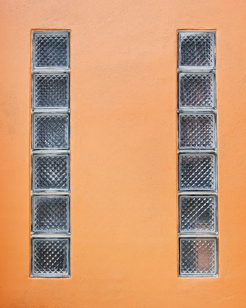 Glasblock på gamla orange cement vägg — Stockfoto